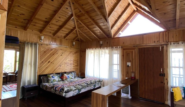 A wooden cottage in an fruits orchard facing Himalayas