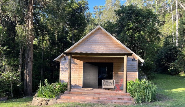 Cedar cabin in serene cool setting in rainforest bush, traditional luxe