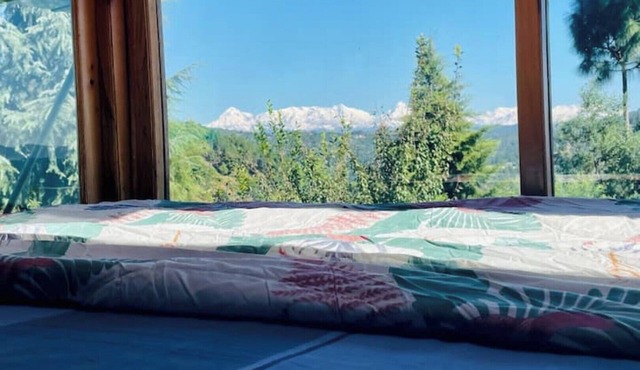 Cozy bungalow nestled in the Himalayas, snow-capped peaks, Kumaoni culture.